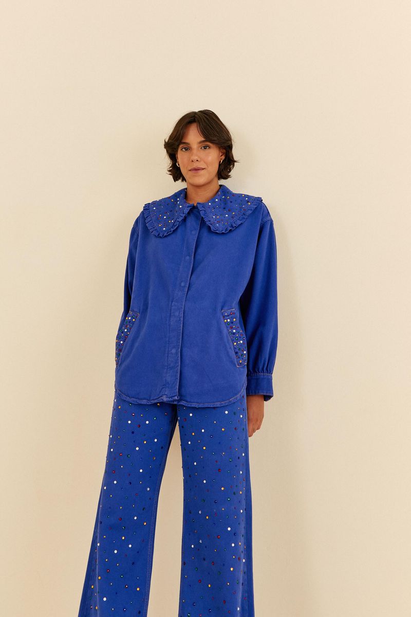 Modelo-usando-pantalon-wide-leg-azul-con-piedrecillas-coloridas-y-camisa-combinada.