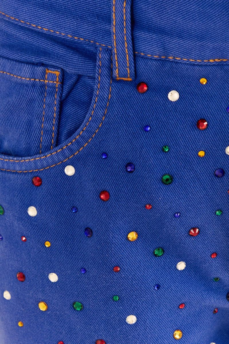 Primer-plano-de-las-piedrecillas-coloridas-aplicadas-en-el-pantalon-wide-leg-azul.