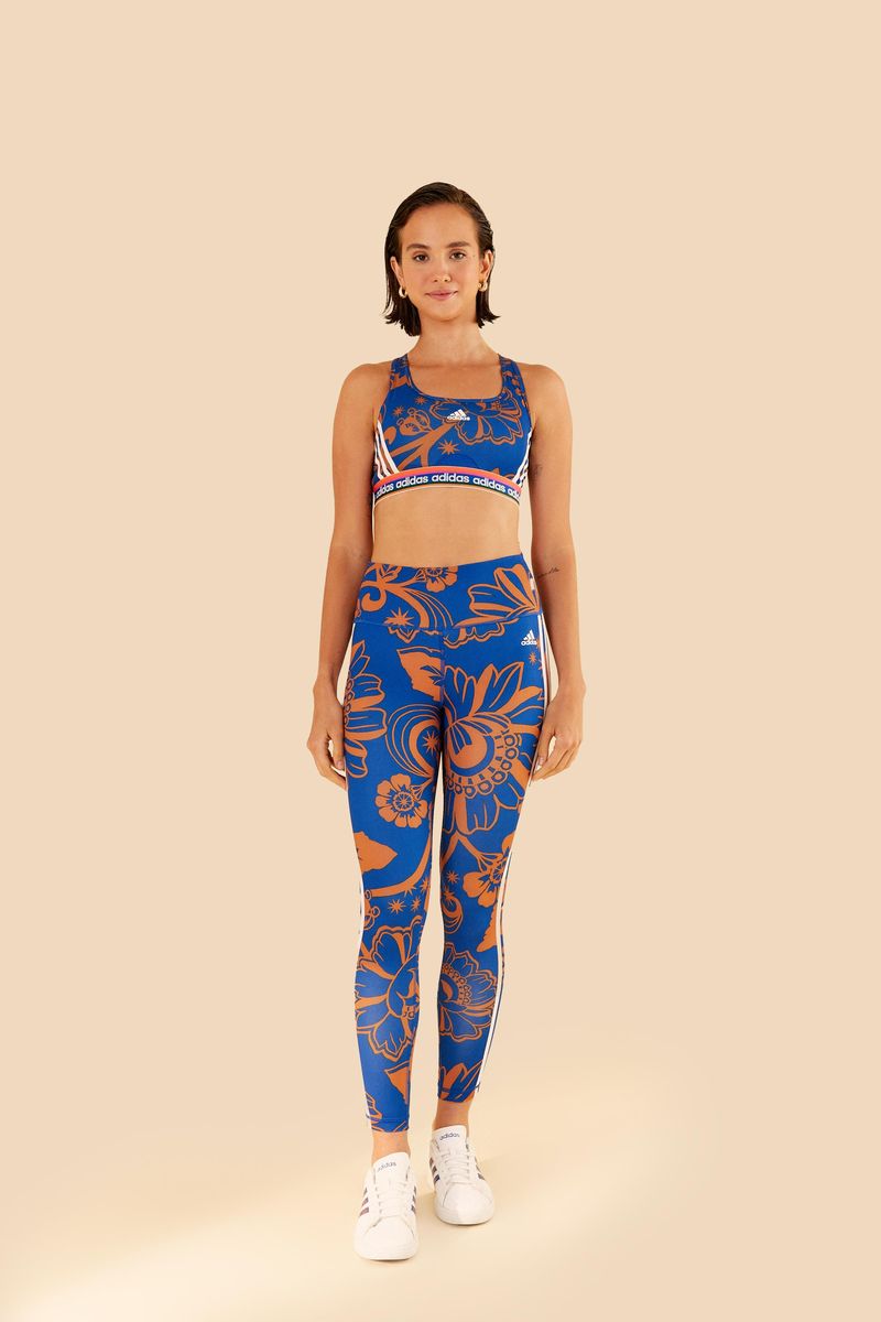 Modelo de pie usando conjunto de top y leggings Adidas Boho Flower Real, vista completa.