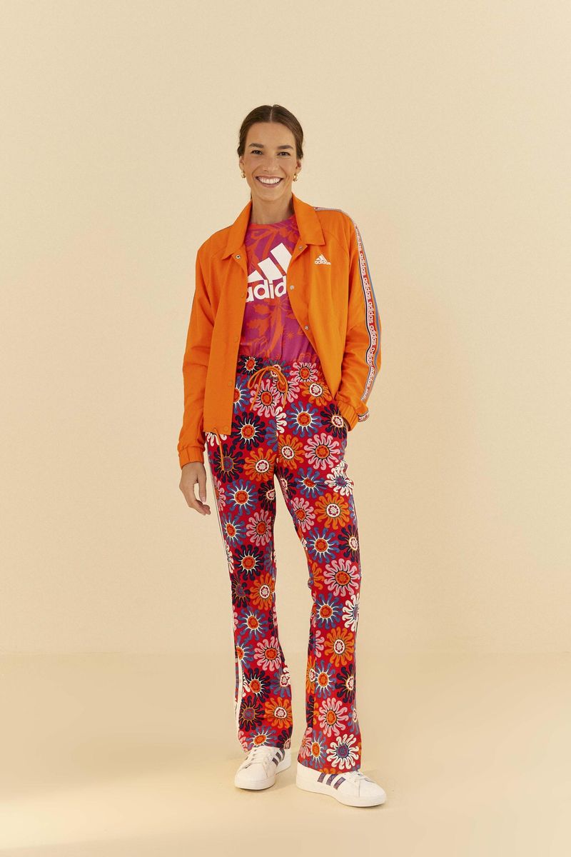 Modelo-vistiendo-conjunto-Adidas-con-chaqueta-naranja-y-pantalon-floral.