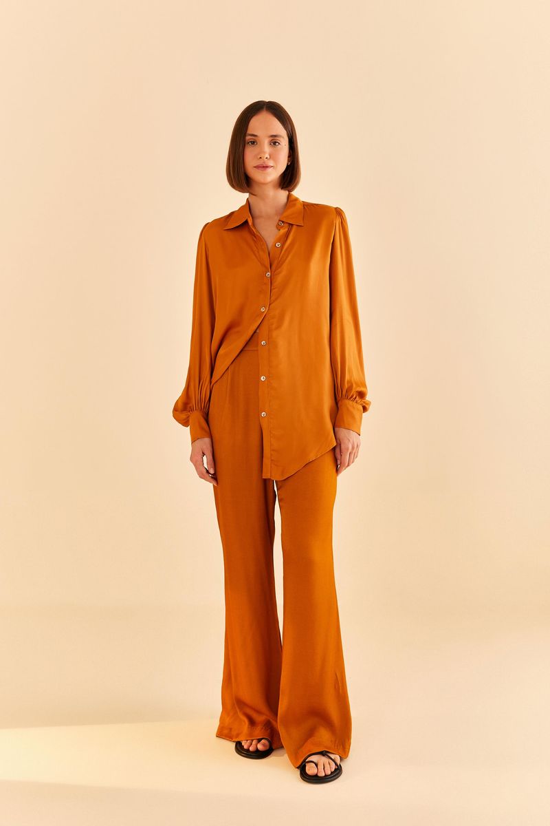 Vista-lateral-del-pantalon-flare-de-saten-en-tono-ocre-destacando-la-caida.
