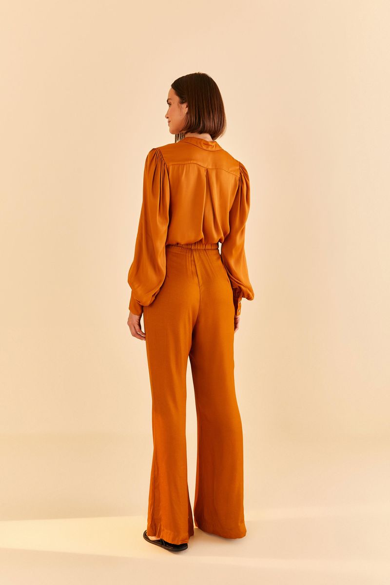 Vista-trasera-del-pantalon-flare-de-saten-en-tono-ocre-mostrando-el-ajuste.