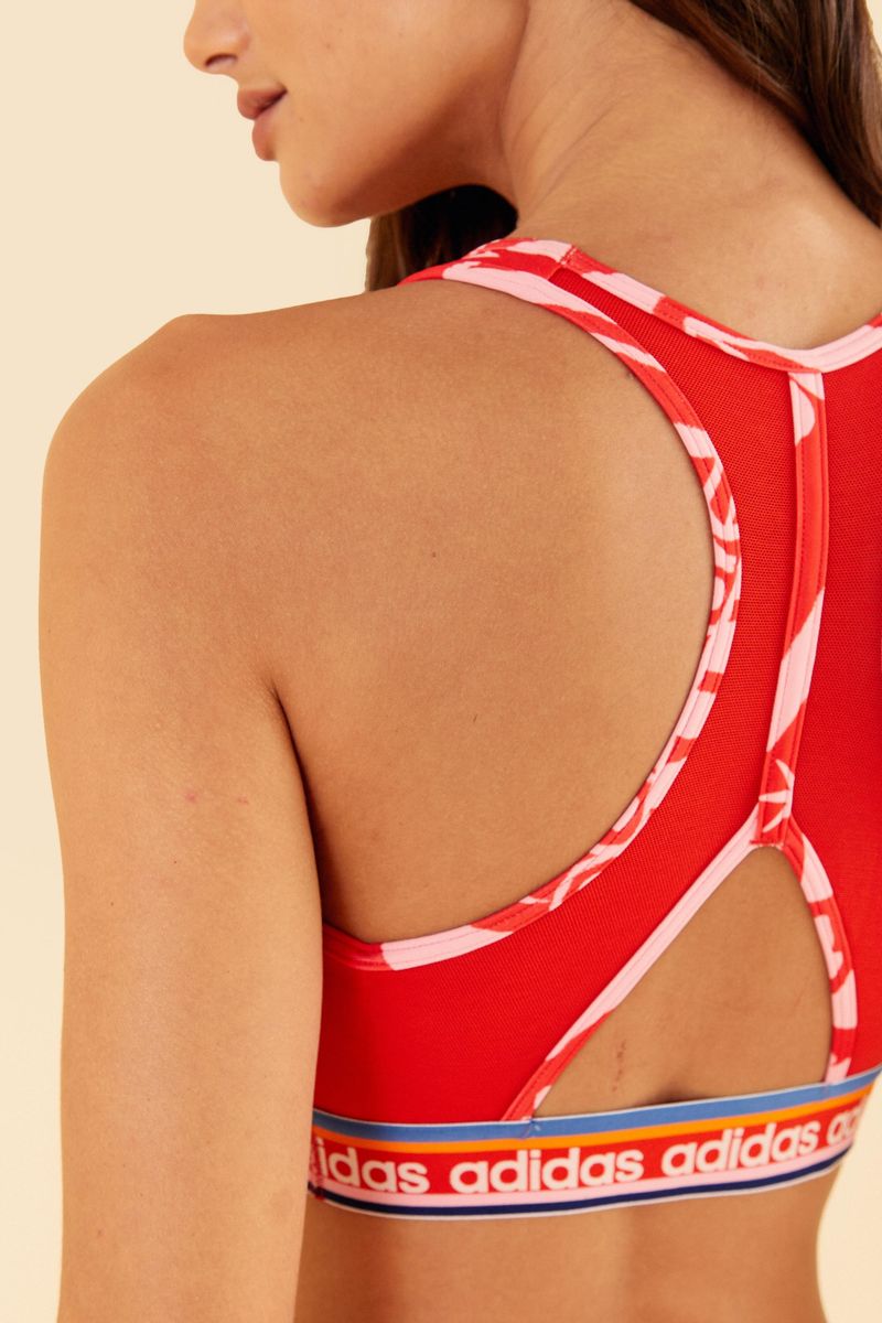 Detalle del escote deportivo del top Adidas Boho Flower Bahia Magenta, con estampado floral vibrante.