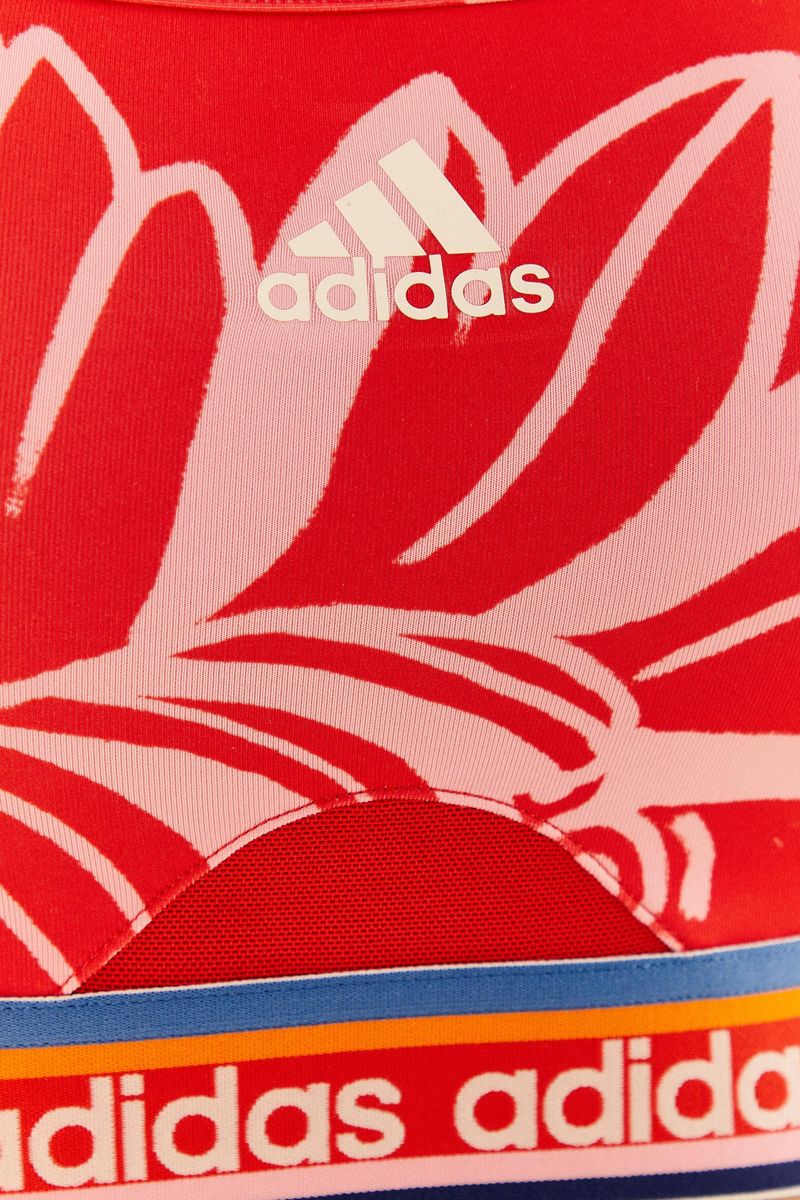Acercamiento de la estampado floral y el elástico decorativo del top Adidas Boho Flower Bahia Magenta.