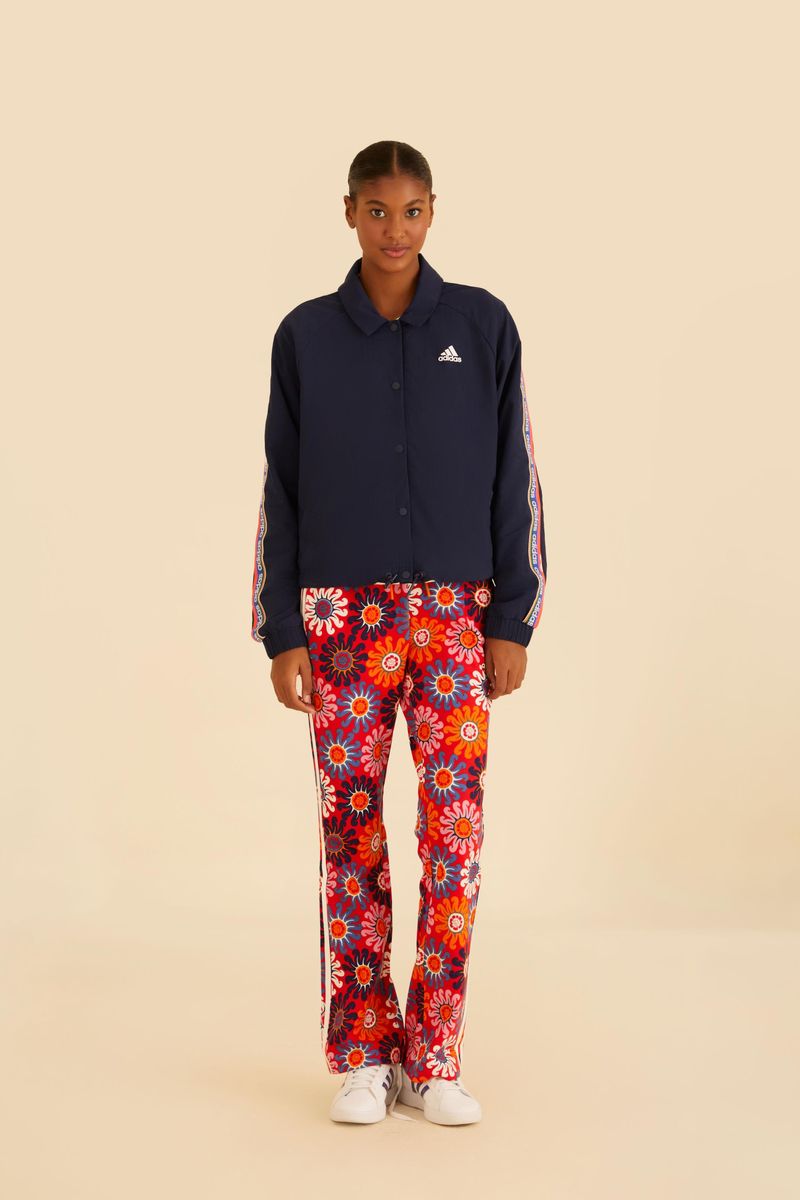 Modelo vistiendo pantalón flare estampado rojo con camisa azul oscuro.