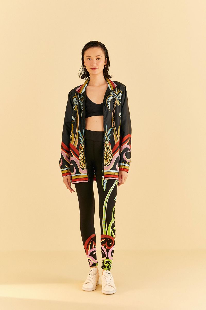 Modelo-de-pie-llevando-una-legging-estampada-y-chaqueta-mostrando-el-conjunto.