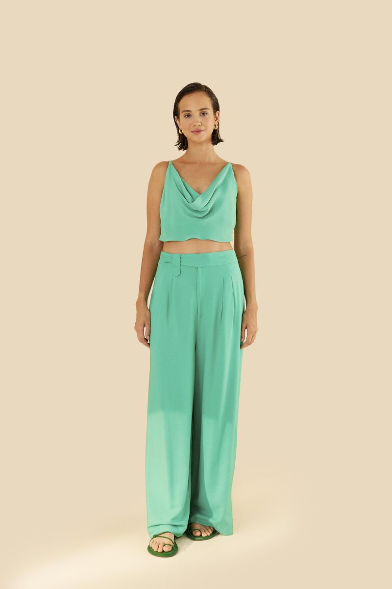 Imagen de una modelo vistiendo un pantalón recto verde claro con pinzas y cintura alta.