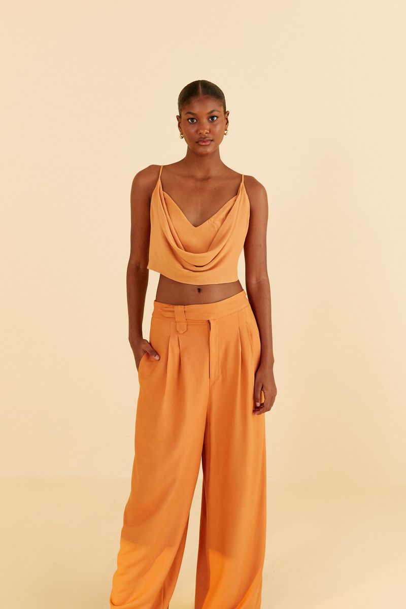 Modelo-llevando-pantalon-recto-con-pliegues-en-tejido-ocre-vista-lateral.