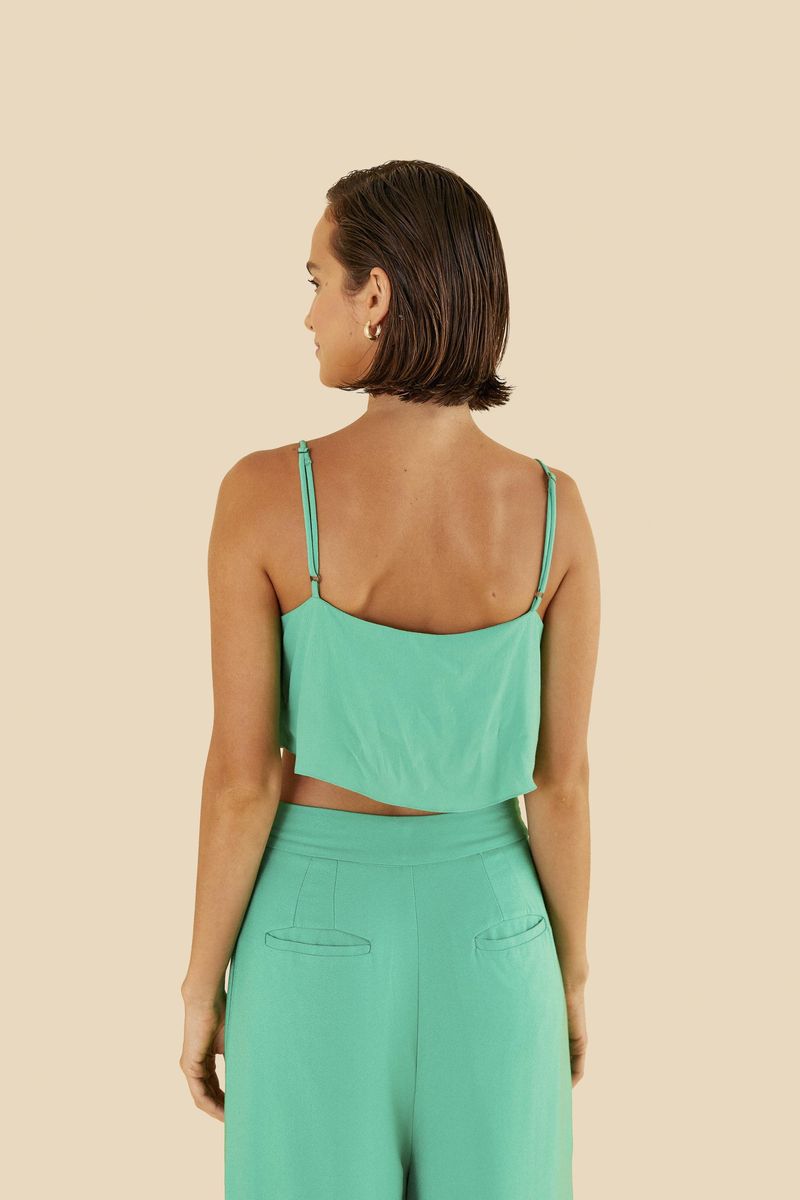 Close-up del escote degagê de la blusa verde.