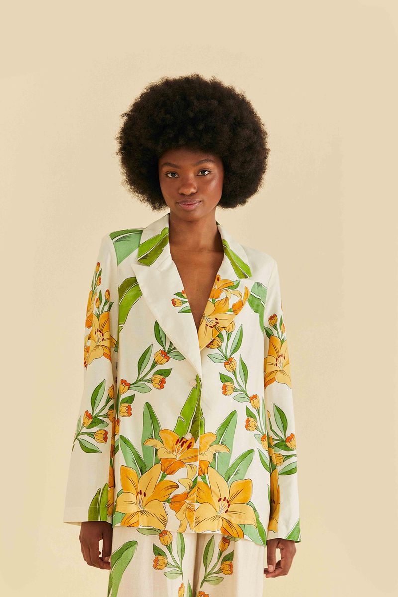 Blazer estampado tropical con flores y follajes en tonos de verde y amarillo, visto de frente.