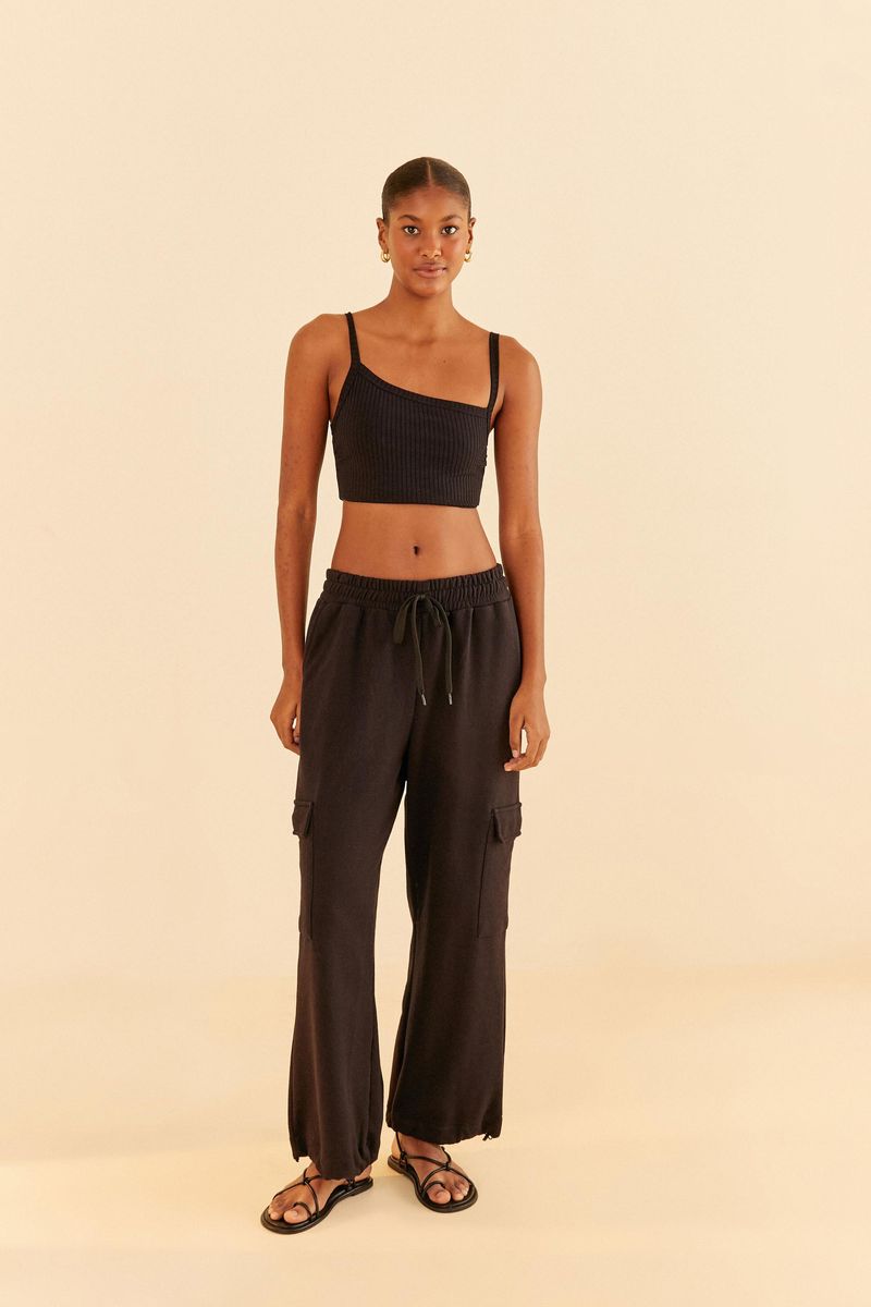 Modelo-vistiendo-top-negro-asimetrico-con-pantalon-negro.