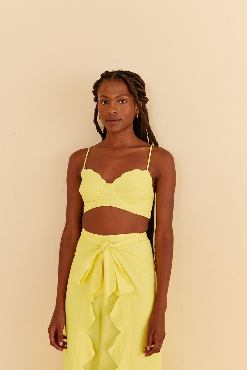 Modelo-vistiendo-un-top-amarillo-con-escote-en-forma-de-nube-y-tiras-delgadas-ajustables.