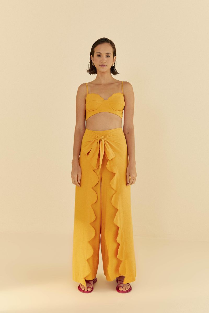 Vista-frontal-del-top-amarillo-combinado-con-un-pantalon-largo-con-detalles-ondulados.
