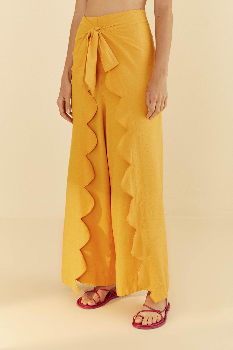 Detalle de cintura alta con lazada del pantalón largo ocre.