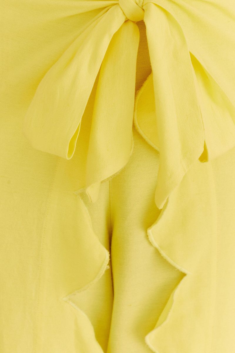 Close-up del acabado vertical de nube en el frente del pantalón amarillo.