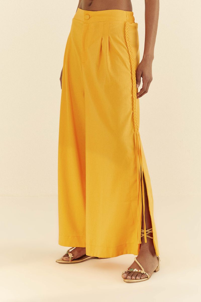 Vista-lateral-del-pantalon-amarillo-mostrando-los-detalles-trenzados-y-las-aberturas.