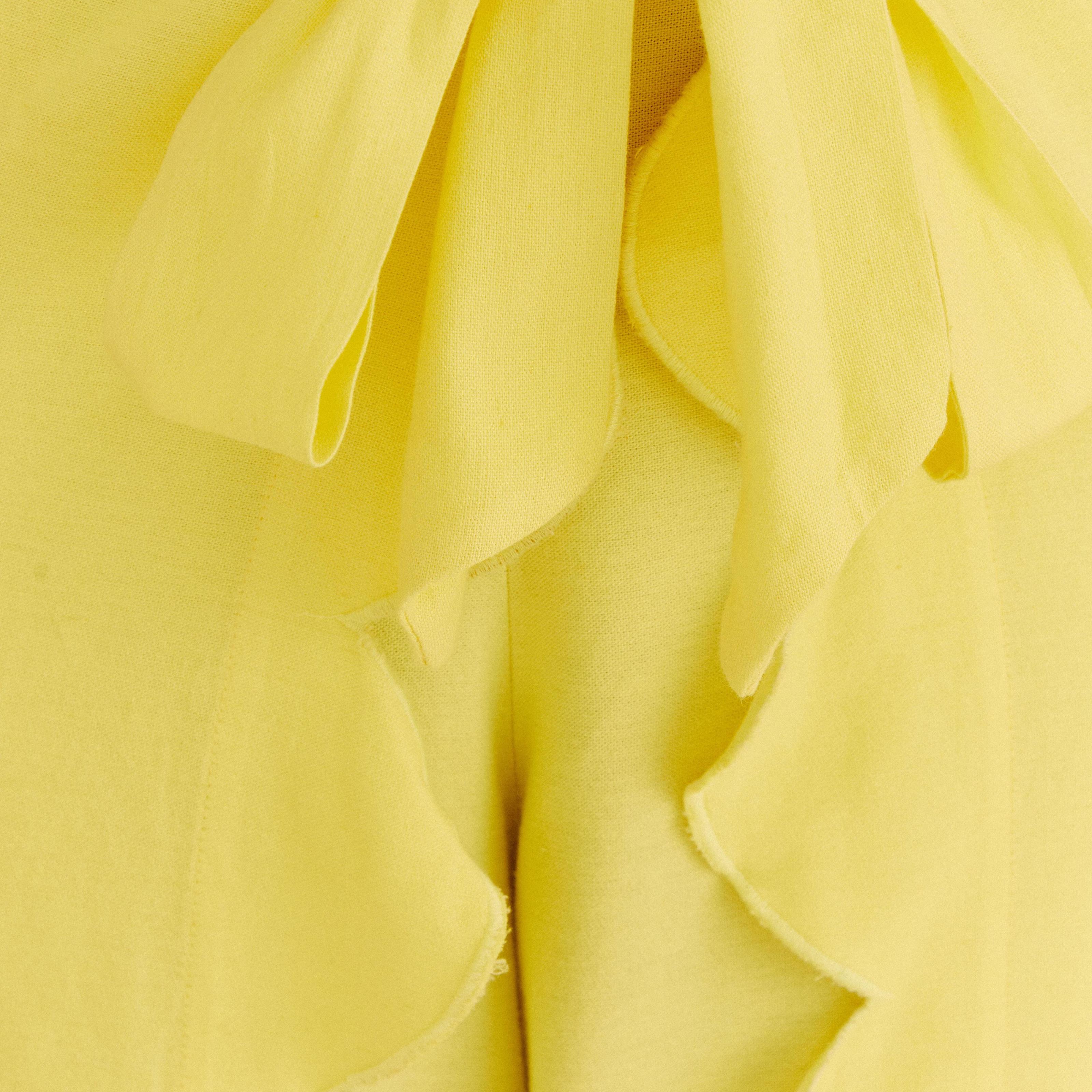Detalle ampliado de la tela y el acabado del pantalón amarillo.