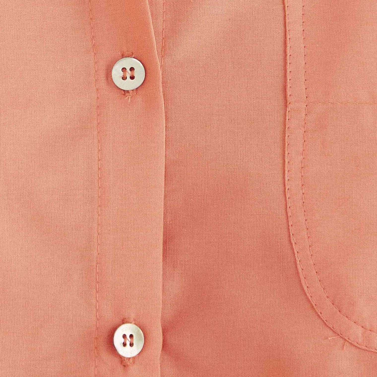 Detalle-del-unico-bolsillo-en-el-pecho-de-la-camisa-rosa.