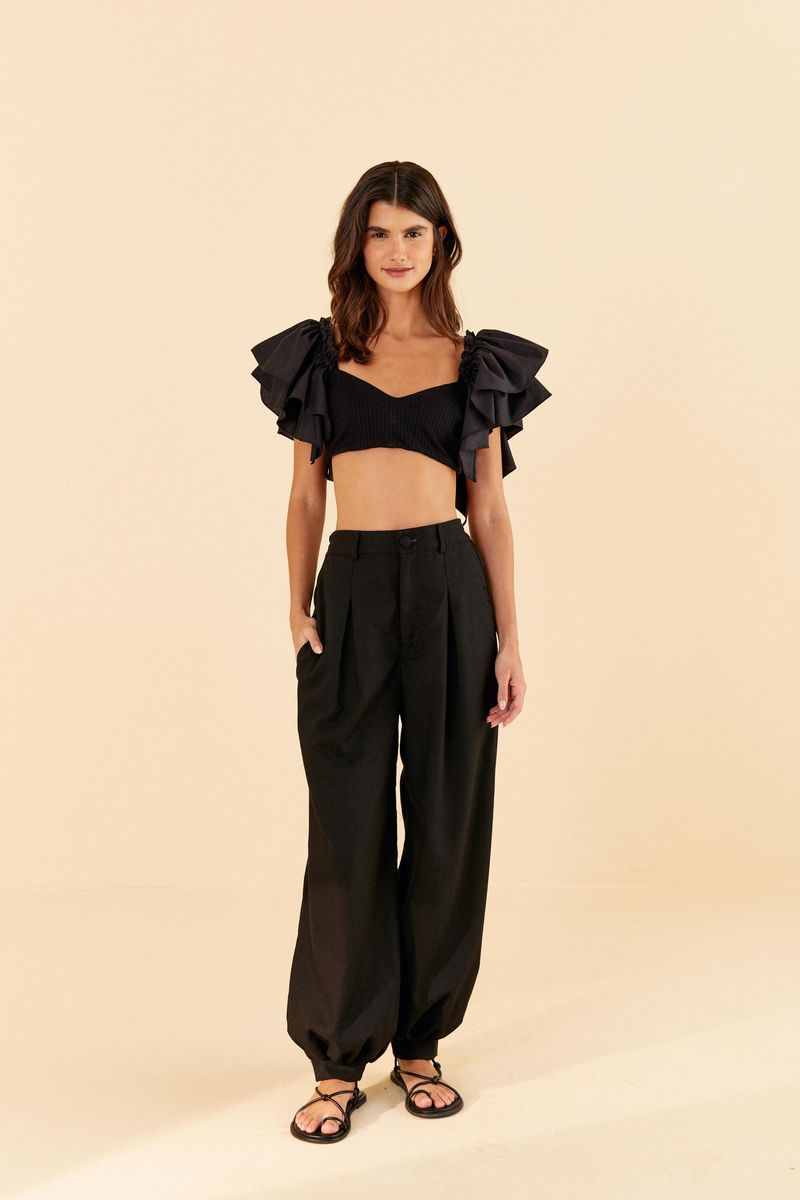Top-negro-con-mangas-voluminosas-estilo-capa-combinado-con-pantalon-negro.