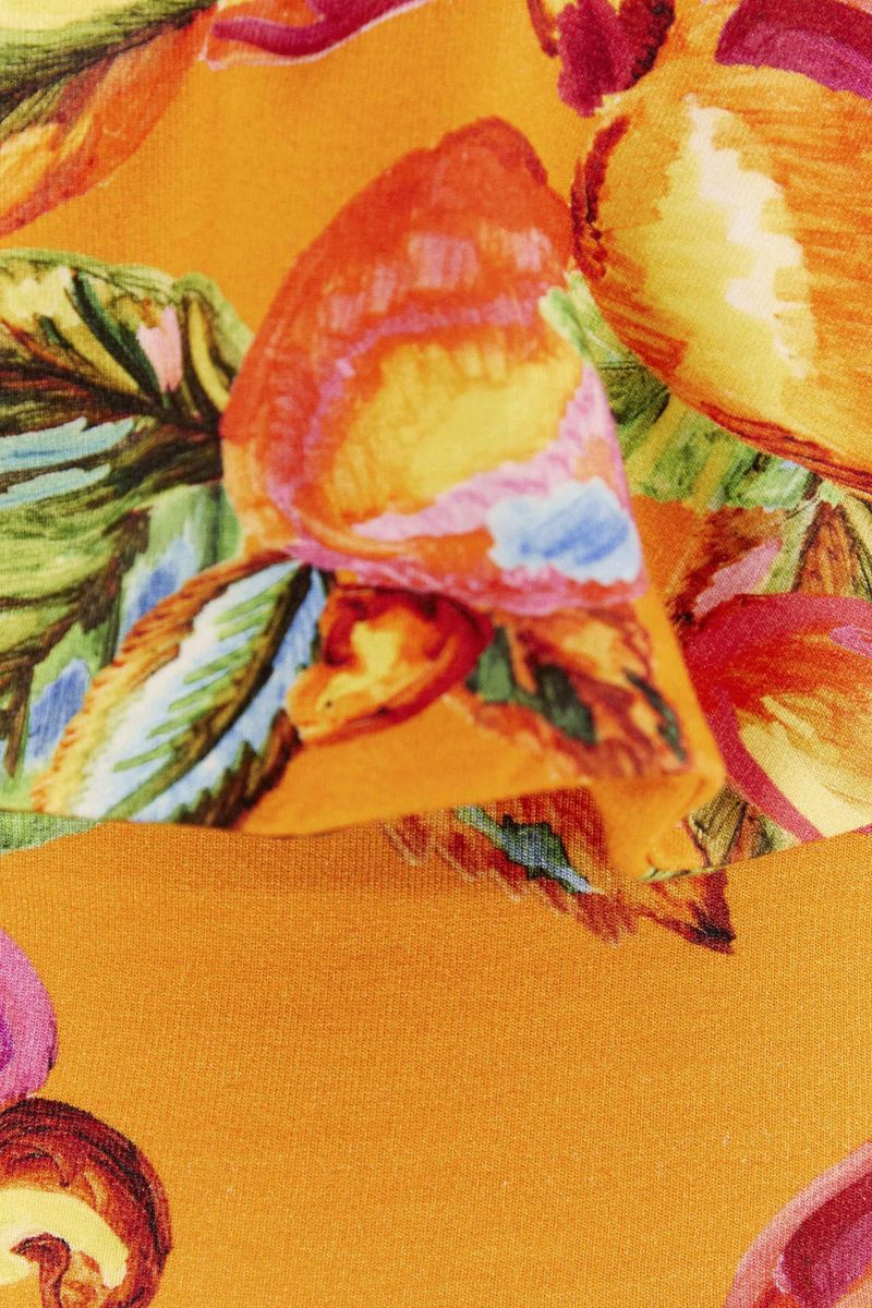 Primer plano del estampado tropical con motivos de frutas y follaje.