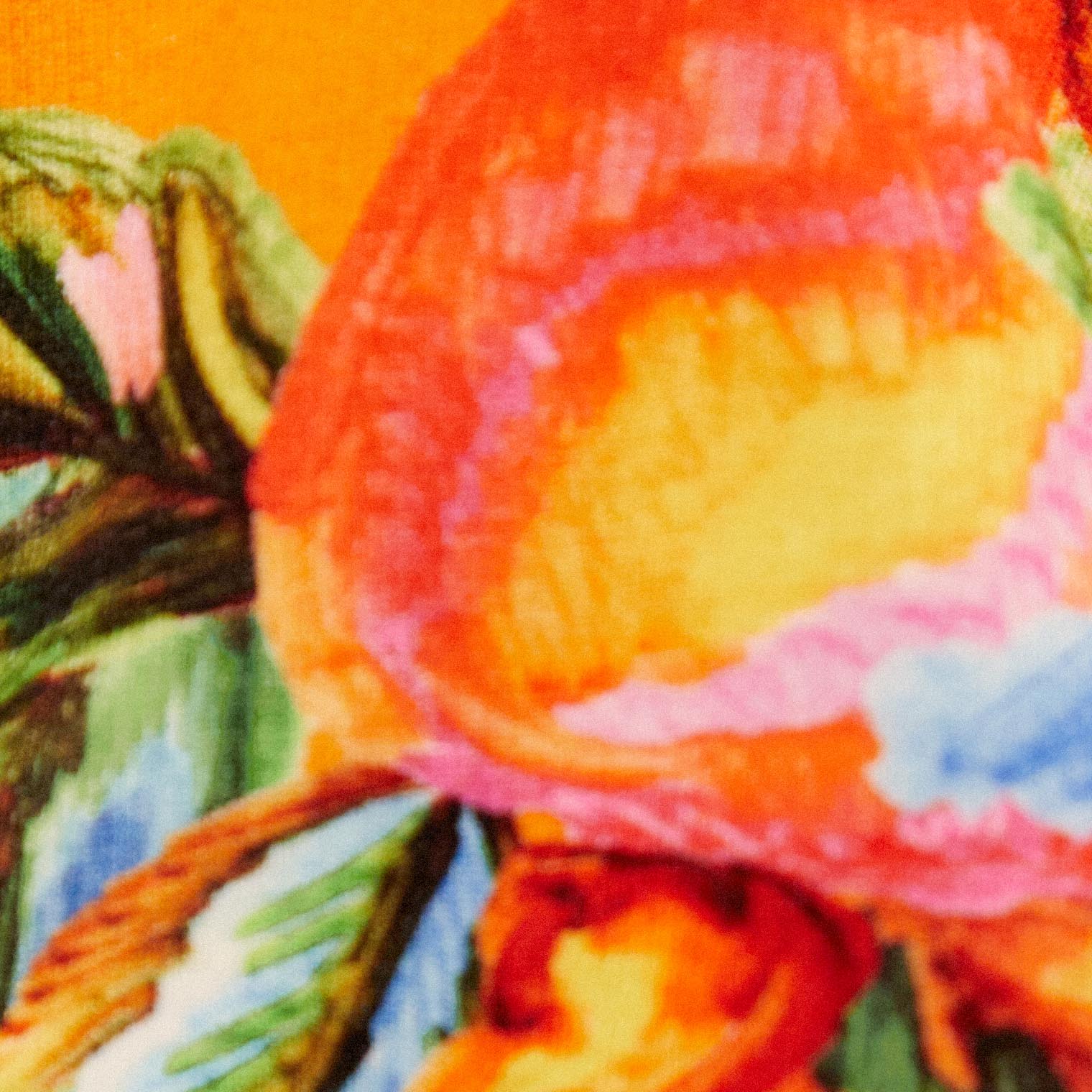 Primer plano del estampado tropical con motivos de frutas y follaje en fondo amarillo.