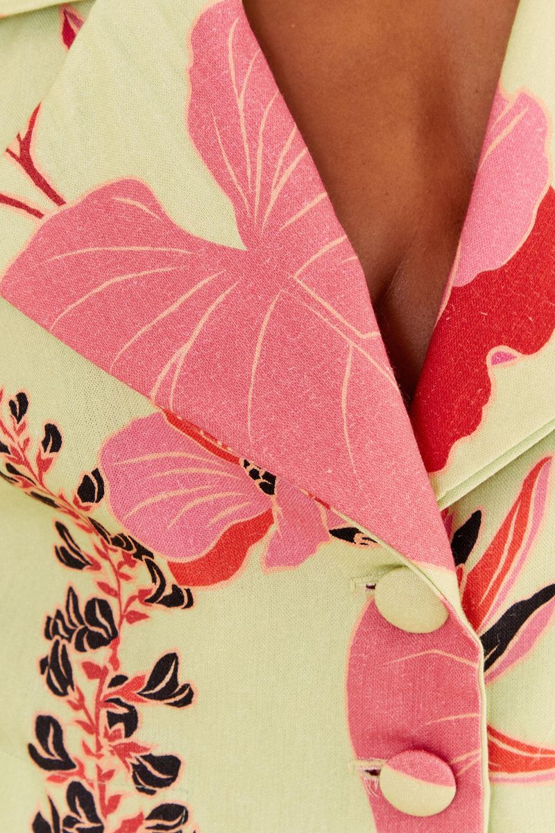 Primer plano de la solapa del blazer floral con botones decorativos.