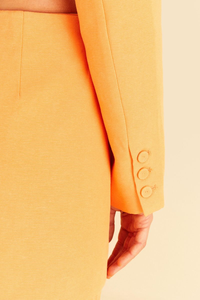 Detalle-de-los-botones-en-los-puños-del-blazer-naranja.