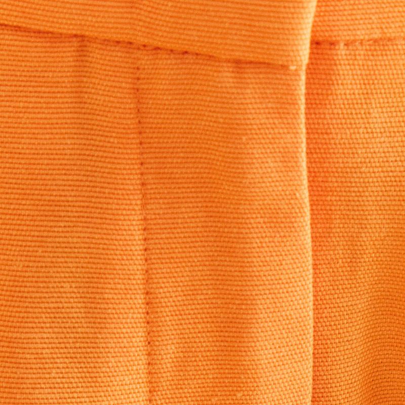 Acercamiento de la cintura del pantalón de sastrería naranja mostrando los pasadores y el acabado.