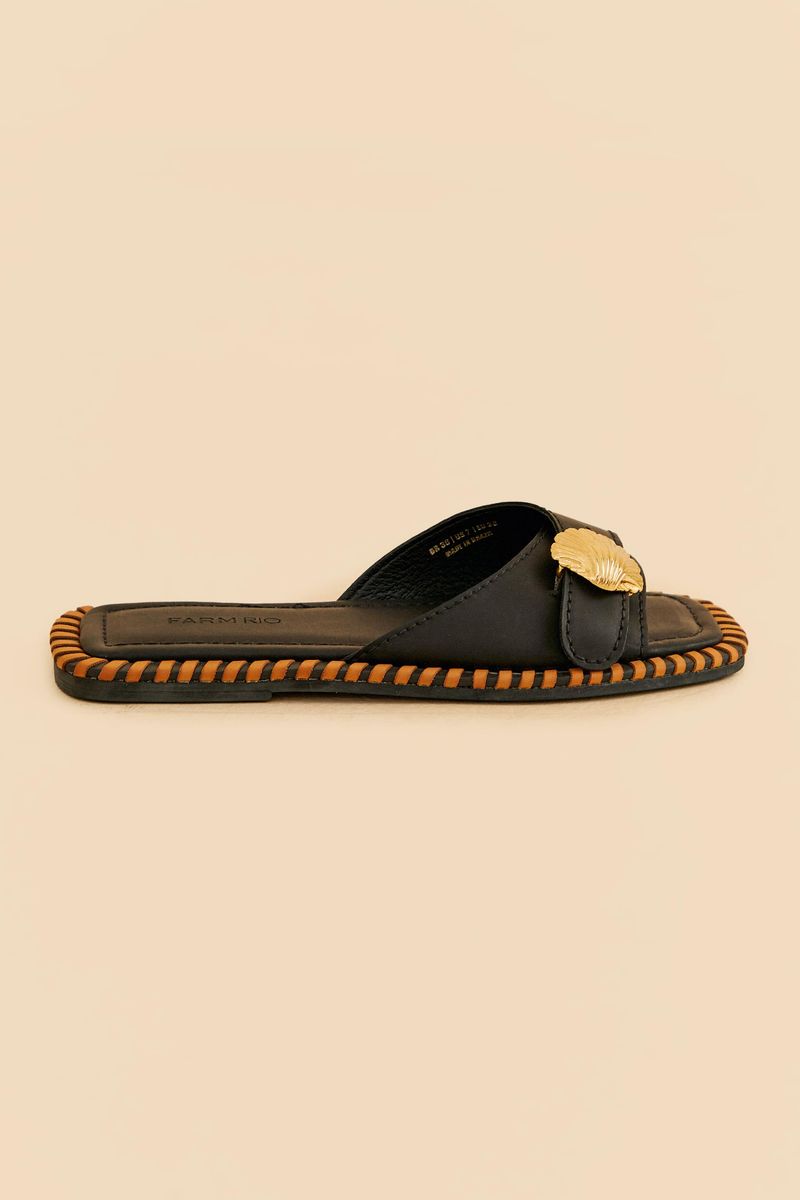 Sandalia-Bajita-Slipper-en-tono-lila-con-detalle-metalico-en-forma-de-concha-vista-lateral.