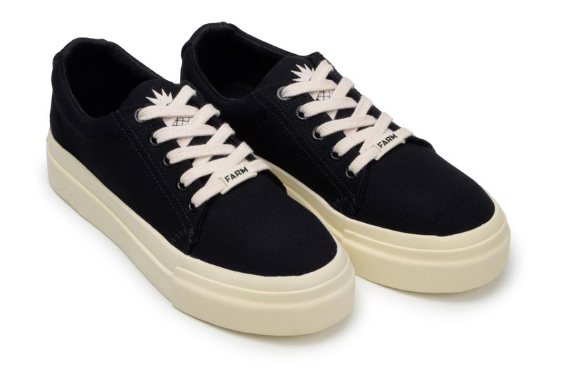 Zapatos-casuales-negros-con-suela-beige-y-cordones-blancos-vistos-de-lado.