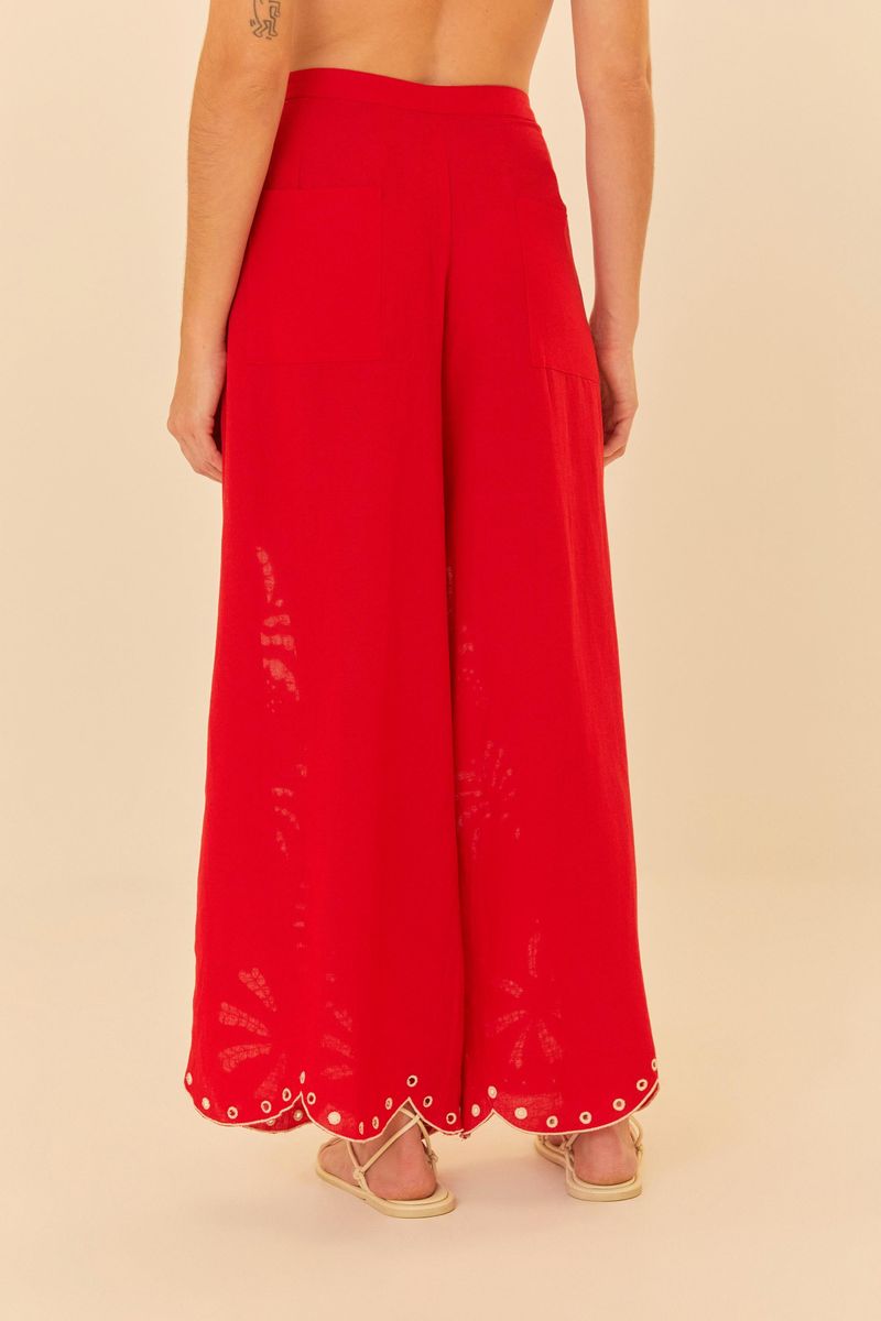 Primer-plano-de-los-bordados-botanicos-en-la-barra-del-pantalon-rojo-destacando-los-detalles.