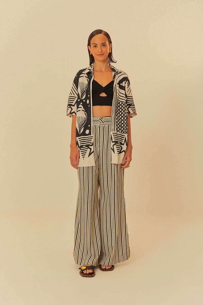 Modelo-vistiendo-el-top-negro-con-pantalon-rayado-y-camisa-estampada-mostrando-un-conjunto-completo.