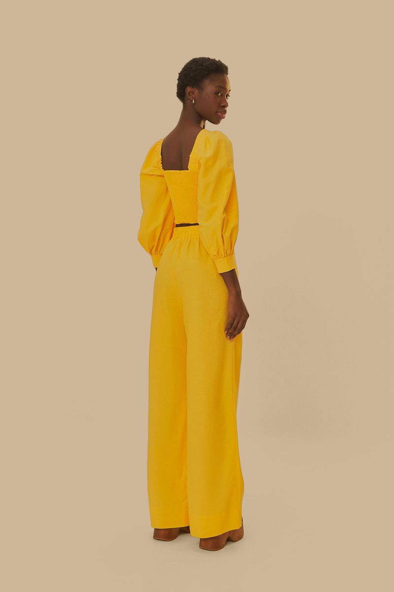 Vista-trasera-del-pantalon-amarillo-mostrando-el-corte-recto-y-fluido.