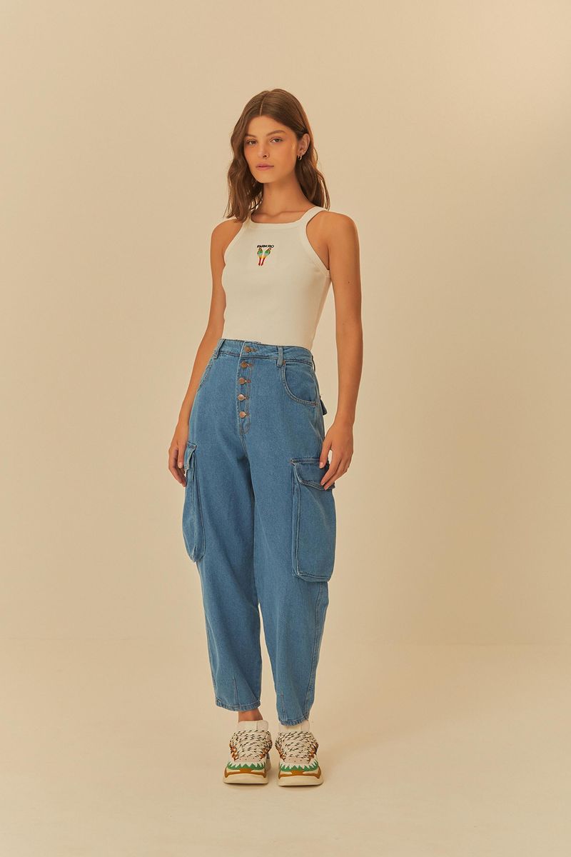 Vista completa de un modelo usando el Pantalón Jeans Baggy Cargo, combinado con una camiseta sin mangas blanca y zapatillas, destacando el ajuste relajado y el estilo urbano