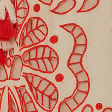 Imagen-de-un-vestido-blanco-con-bordados-rojos-en-estilo-richelieu-mostrando-detalles-del-tejido.