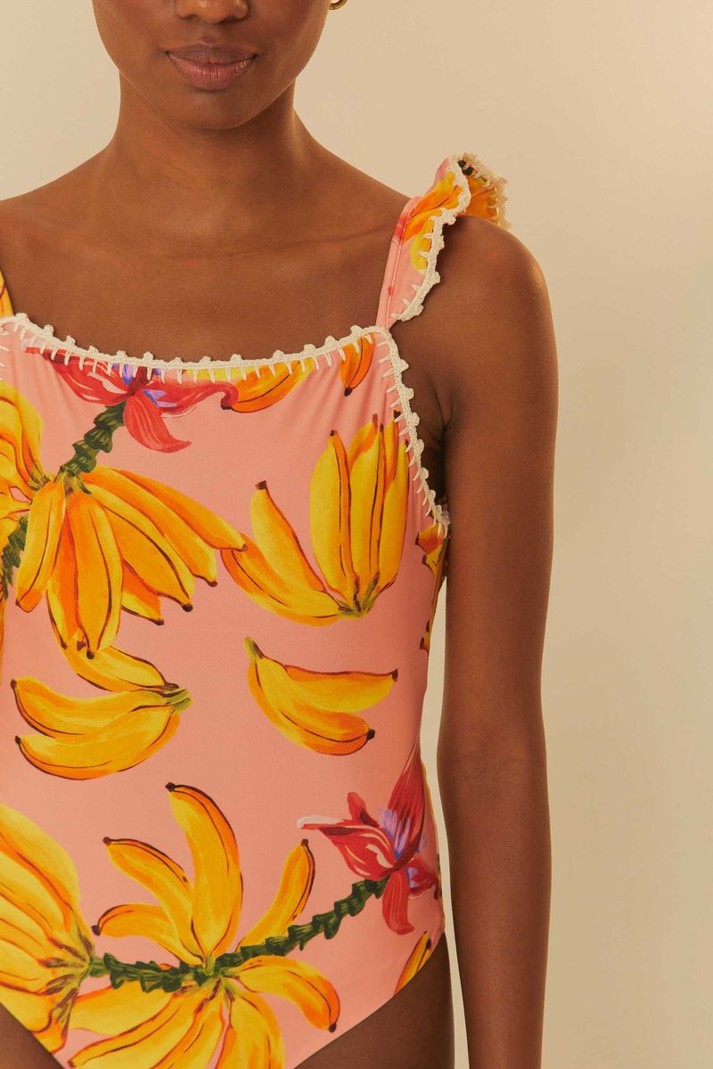 Primer-plano-del-traje-de-baño-con-estampado-de-bananos-sobre-fondo-rosa-mostrando-detalles-de-los-hombros.