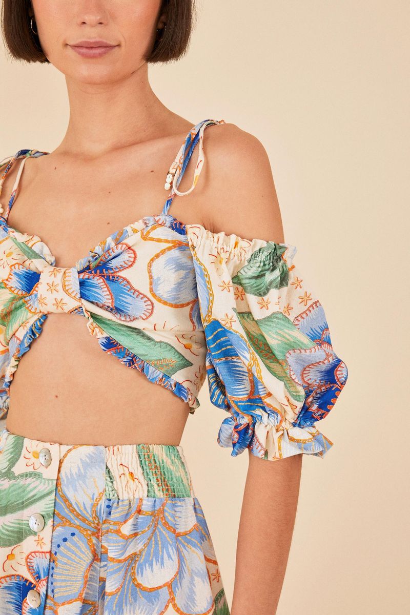 Detalle del estampado floral vibrante en tonos de azul y verde.