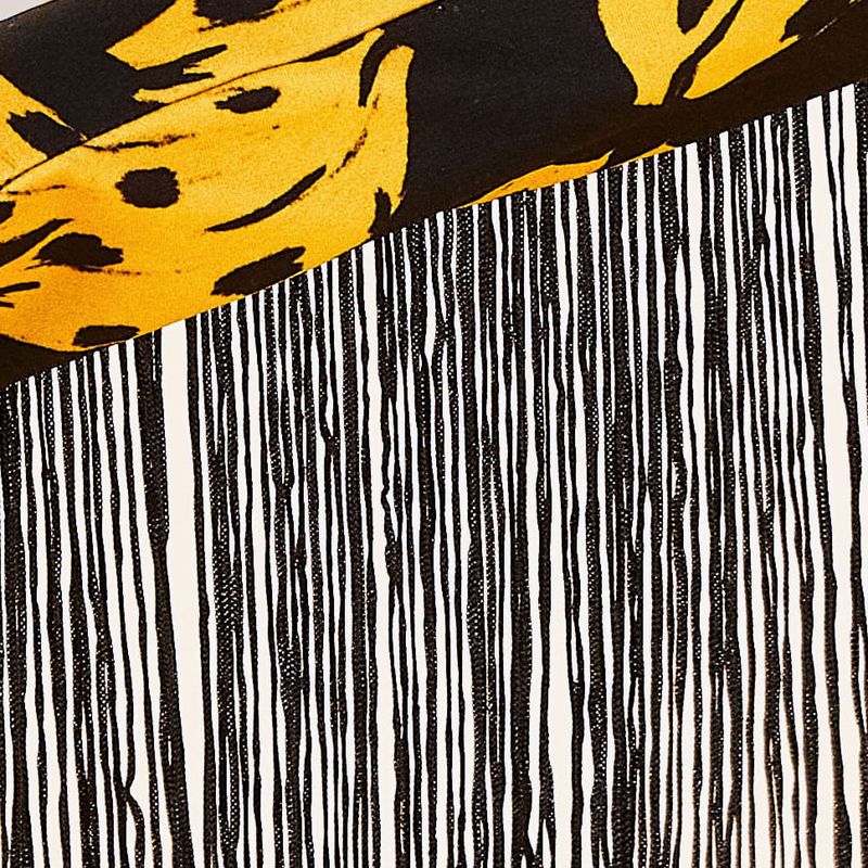 Imagen-de-un-guante-largo-estampado-con-bananas-en-fondo-negro-con-flecos-en-los-laterales-mostrando-detalles-del-estampado.