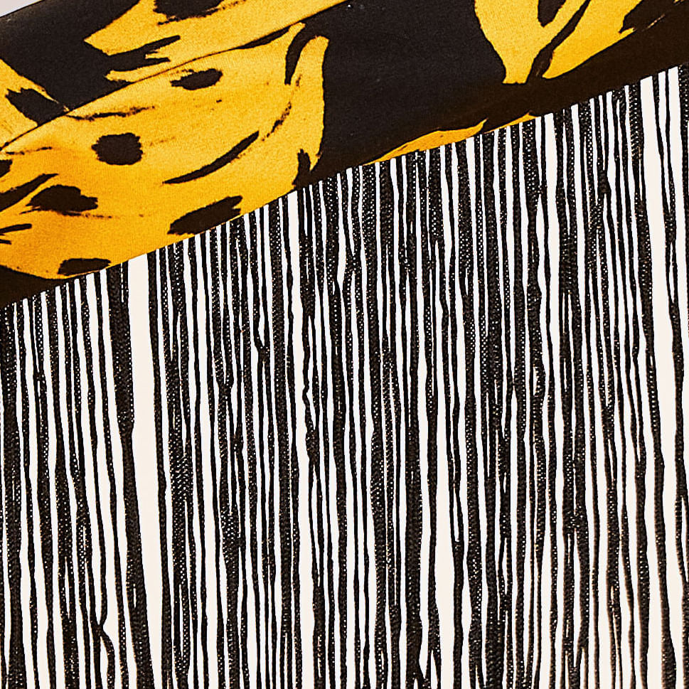 Imagen-de-un-guante-largo-estampado-con-bananas-en-fondo-negro-con-flecos-en-los-laterales-mostrando-detalles-del-estampado.