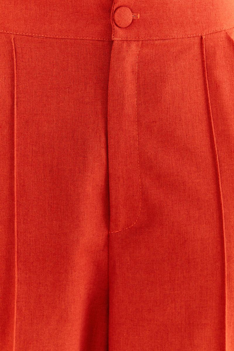 Imagen-de-una-modelo-luciendo-un-pantalon-flare-largo-rojo-detalle-del-tejido-y-acabado.