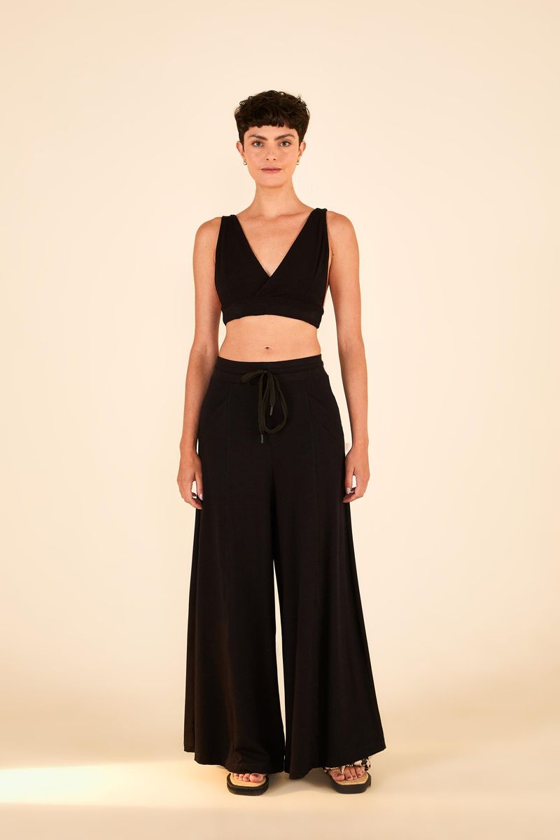 Imagen-de-una-modelo-vistiendo-el-top-negro-con-tela-acanalada-y-escote-en-V-combinado-con-un-pantalon-amplio-negro.