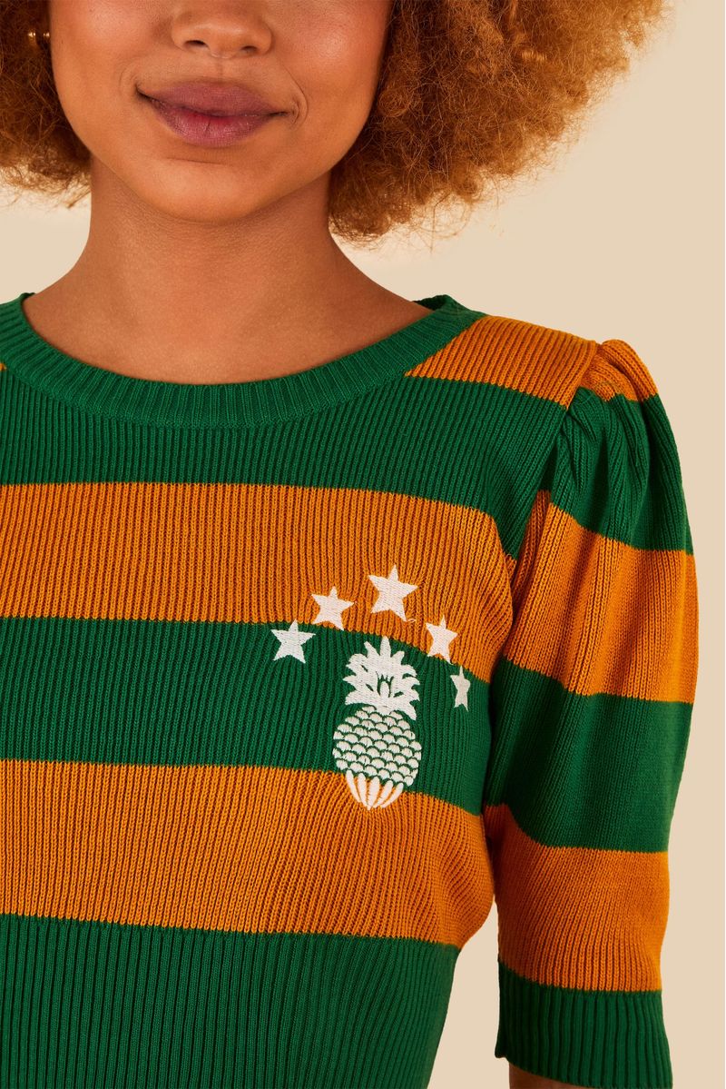 Detalle del bordado de piña y estrellas en la blusa.