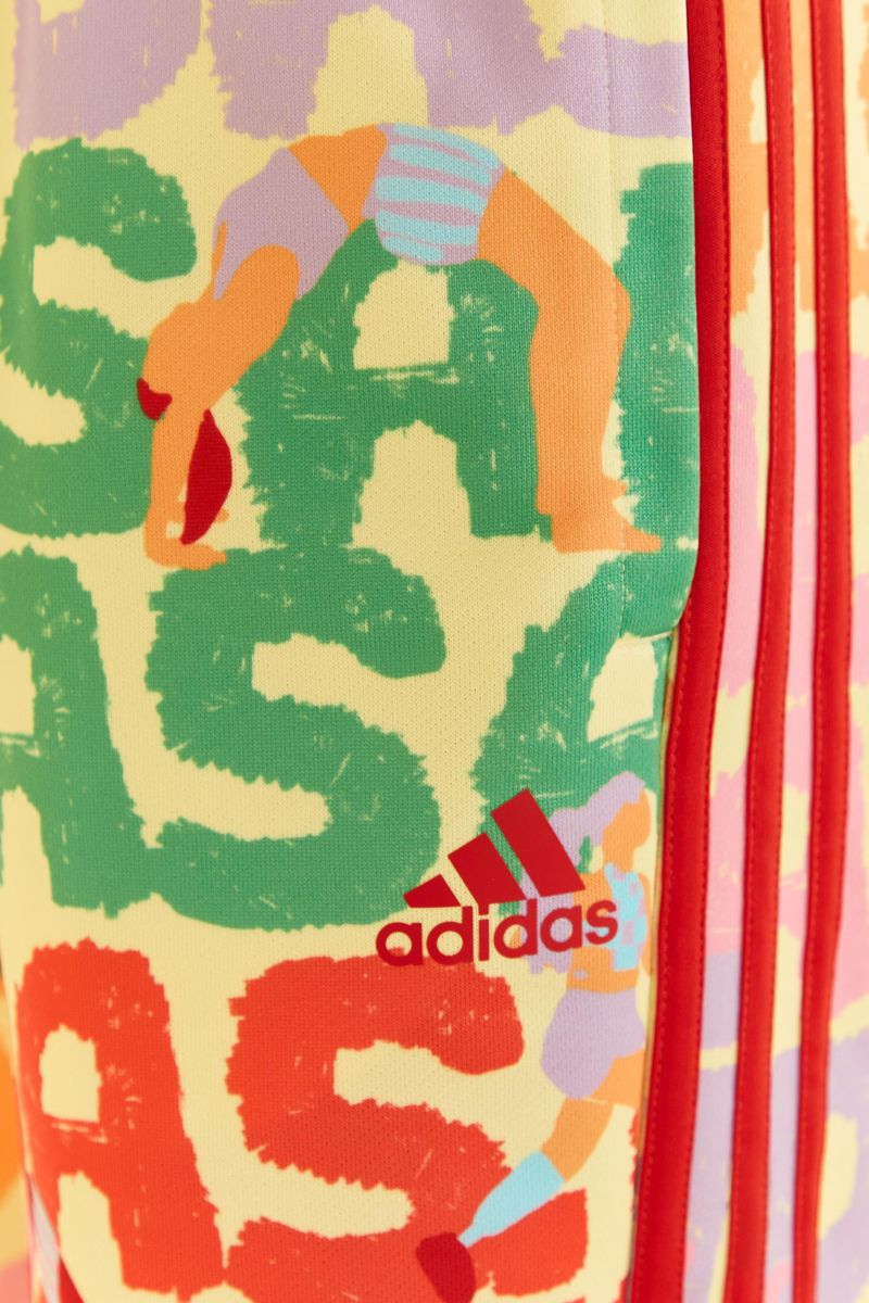 Primer-plano-del-logo-Adidas-en-el-pantalon-estampado-con-franjas-laterales.