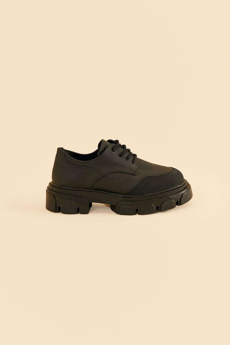 Imagen-de-un-zapato-oxford-negro-con-suela-gruesa-vista-lateral.