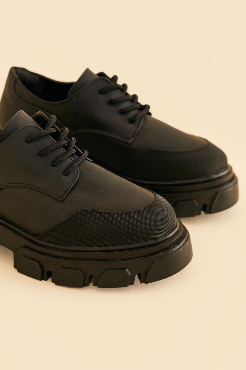 Imagen-de-un-par-de-zapatos-oxford-negro-con-suela-gruesa-vista-superior.