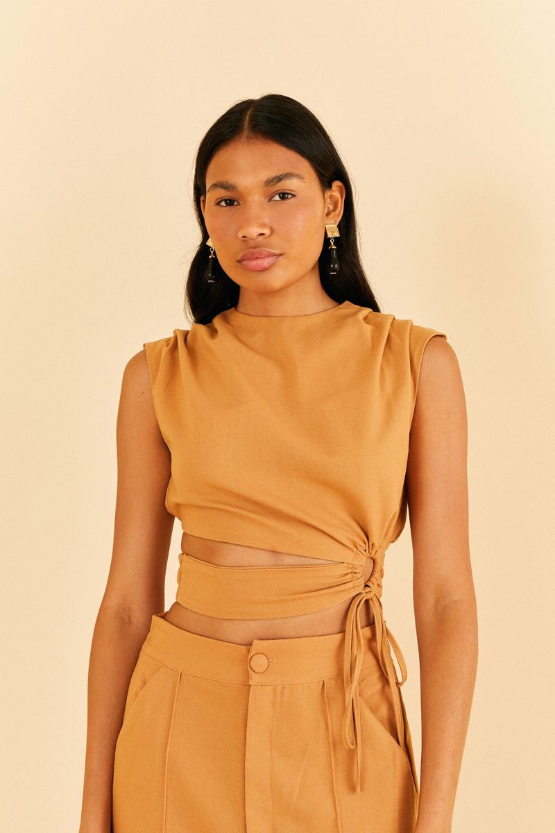 Imagen de una blusa corta con pliegues y argolla, vista desde el frente, destacando el diseño moderno y elegante.