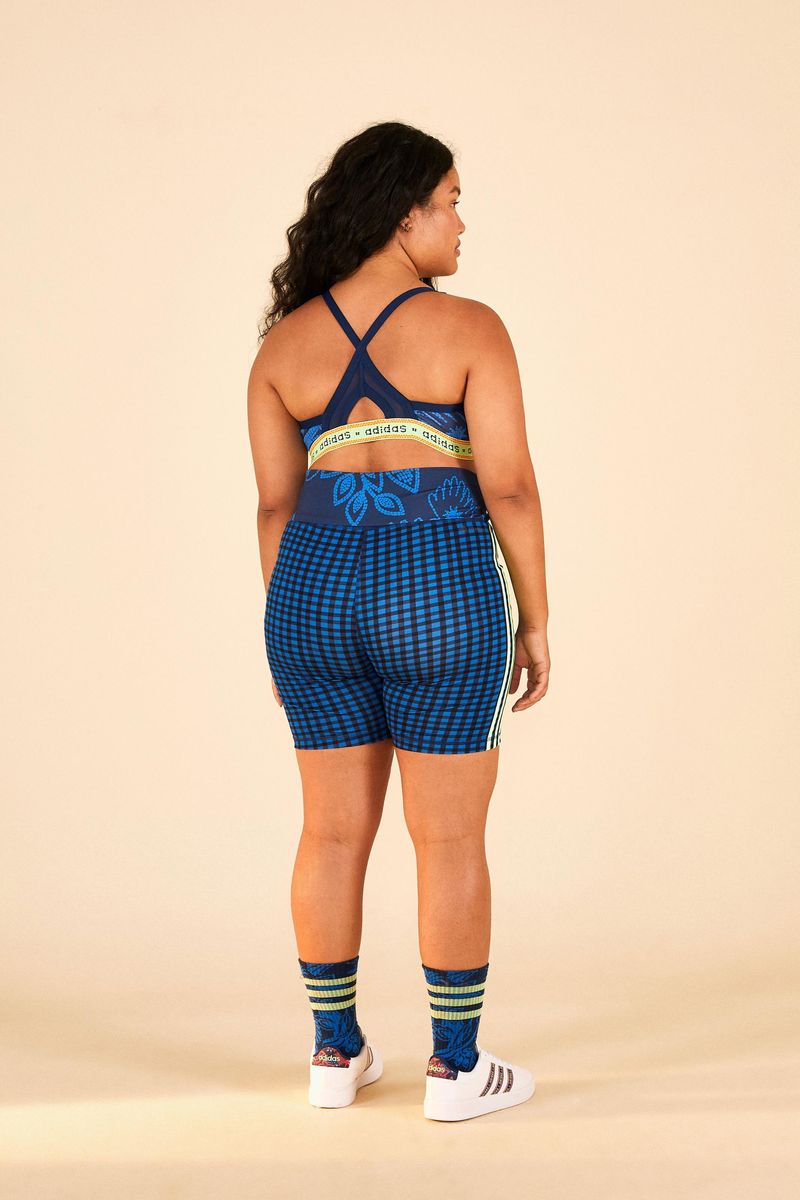 Modelo-usando-top-Adidas-estampado-con-shorts-y-tenis-vista-lateral.