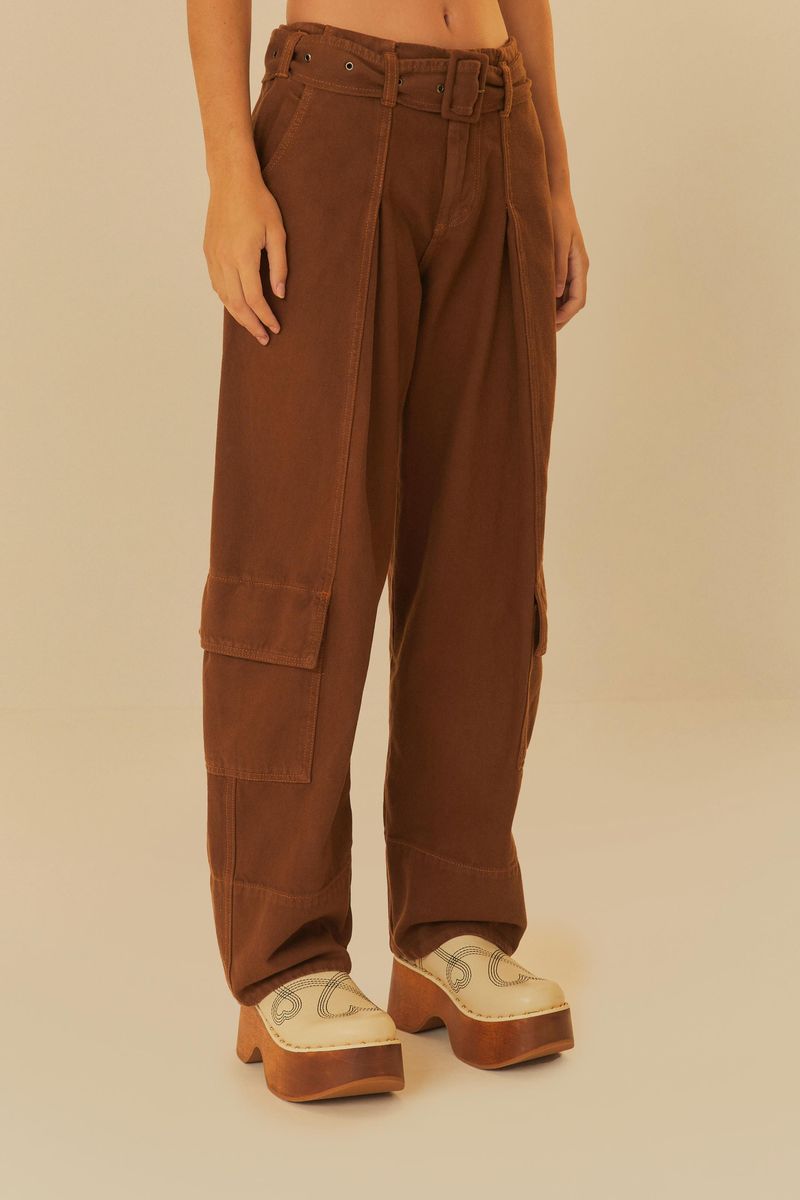 Primer plano de los pantalones cargo de sarga marrón mostrando el cinturón y los bolsillos laterales, con zapatos de plataforma.