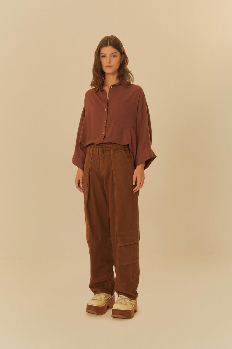Vista frontal completa del modelo usando pantalones cargo de sarga marrón y camisa marrón, con zapatos de plataforma.