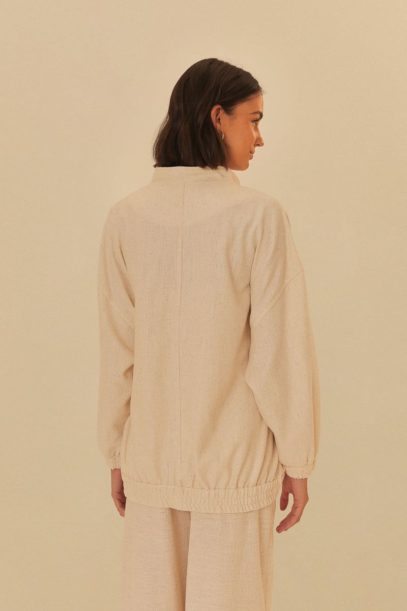 Vista-lateral-de-la-chaqueta-bomber-beige-en-tweed-con-bolsillos-de-solapa.